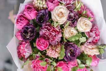 Colorful spring colors. the work of the florist at a flower shop. Purple and pink bouquet of beautiful flowers on wooden table.