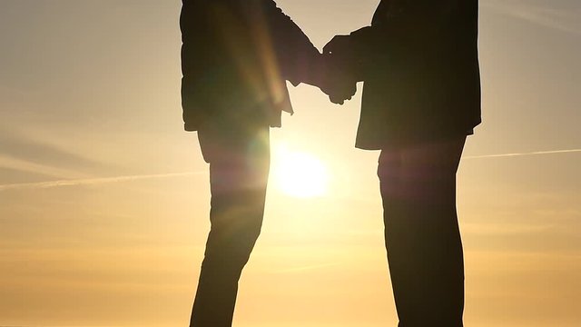 man clasps handcuffs on arrested human hands isolated silhouettes slow motion