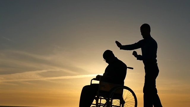 hypnosis session for man in wheelchair silhouettes on sky background slow motion