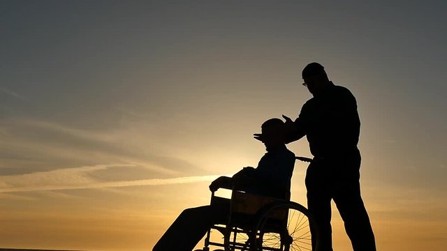 hypnosis session for man in wheelchair silhouettes on sky background slow motion