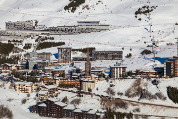 Villages of Les Menuires  at ski resort Val Thorens. Modern bell tower in centre. French alps in winter