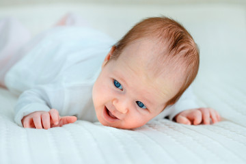 Portrait of a cute newborn baby lying on her stomach