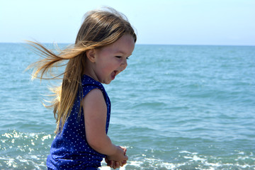 little girl on the beach laughing