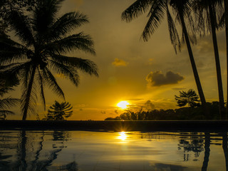 Sonnenuntergang am tropischen Pool mit Palmen