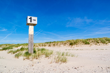 Beach post on sand against blue sky, IJmuiden, Netherlands