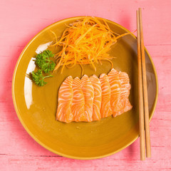 Salmon sashimi on dish on wood color pink