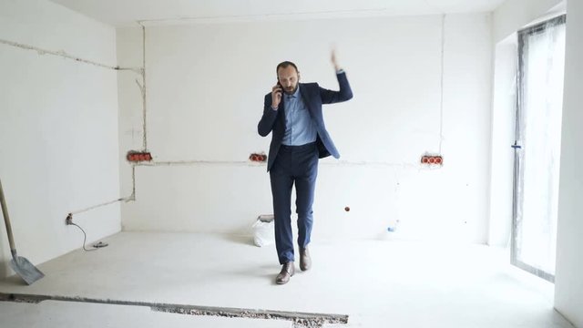 Angry real estate agent talking on cellphone at new home
