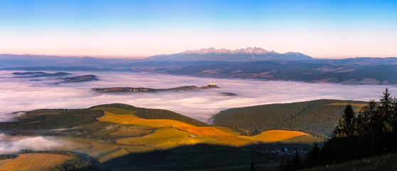 Naklejka na ściany i meble Panoramic landscape view of meadows, castle and mountain range, Slovakia