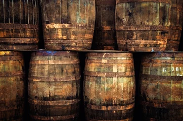Foto auf Acrylglas Detail of stacked old wooden whisky barrels © Martin M303