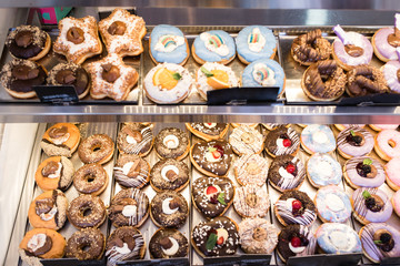 Glazed decorated donuts ready for sale in a small town bakery. 