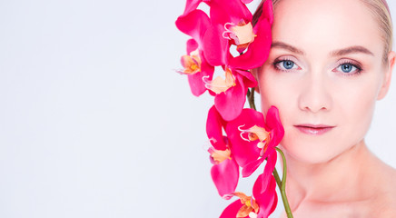 Fototapeta premium Young beauty woman with flower near face