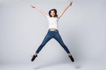 Obraz premium I did it. Dreams come true. Concept of freedom, happiness and life without problems. Vertical full length portrait of happy crazy woman is jumping up, isolated on grey background