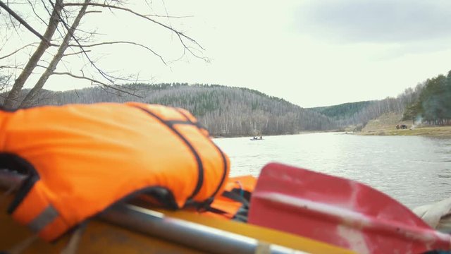 Lifejacket on the inflatable catamaran and the floating boat on the river background