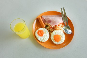 Traditional full English breakfast with fried eggs, sausages and bacon on wooden background 