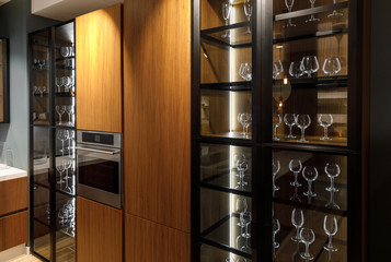 Interior of modern kitchen with glasses in cupboard