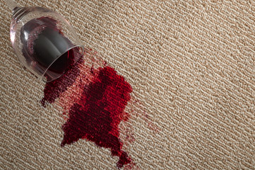 Home mishap, stained carpet and domestic accident concept with top view of  a spilled glass of red...