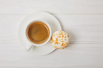 top view of macaroon and coffee cup on white wooden table