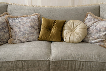 Velvet pillows on grey sofa in room