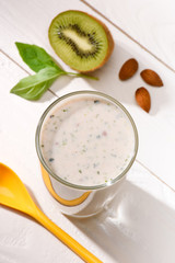 high angle view of protein drink with kiwi on white wooden table