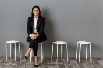 businesswoman in suit looking at camera while waiting for job interview
