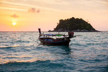 Landscape view of sunset on the sea beach with thai wooden boat at Lipe island, Satun, Thailand