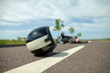 biker helmet lies on street near a motorcycle accident