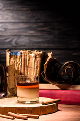 alcohol drink on wooden board with cinnamon sticks on table