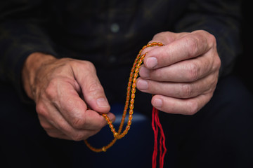 Close view of men's hands with rosary