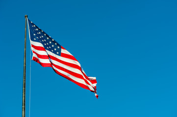 Floating american flag against blue sky, New-York city, USA