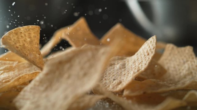 Adding salt on tortilla chips. Shot with high speed camera, phantom flex 4K. Slow Motion.
