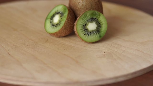 Close-up of ripe sliced kiwi on wooden background. Ripe sliced kiwi on cutting Board, Slow motion.