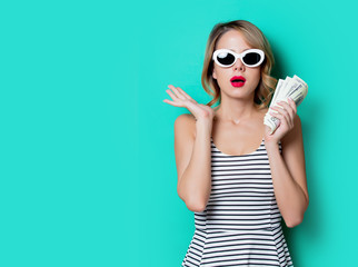 portrait of a young girl in sunglasses with money on green background