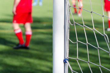 football players out of focus defending the goal