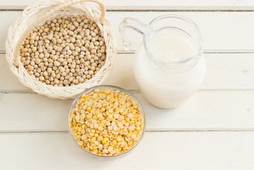 Soy milk and soy beans on wood background.