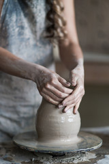 potter sculpts a vase on a potter's wheel