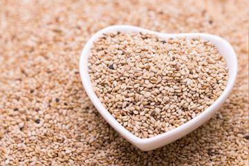 white sesame in wooden spoon on sesame background.