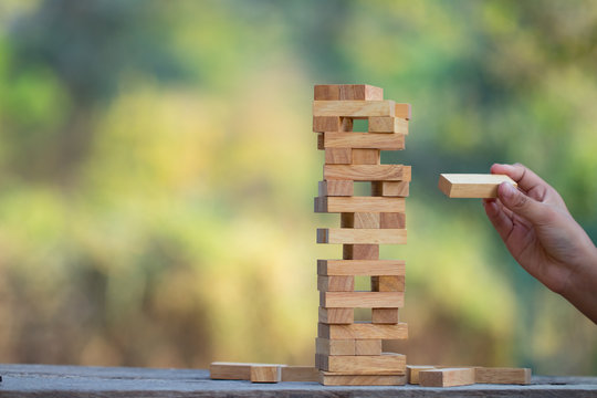 The jenga game ,tower stack from wooden blocks toy and  hand take on block