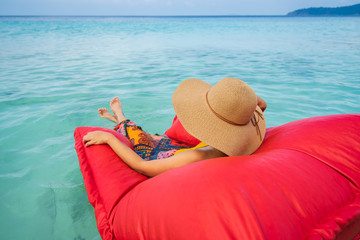 Fototapeta na wymiar Young woman relaxing and enjoying with float mattress at the tropical beach