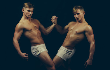 Fototapeta na wymiar Fitness dieting and flexibility in acrobatics. fitness body of twins men isolated on black.