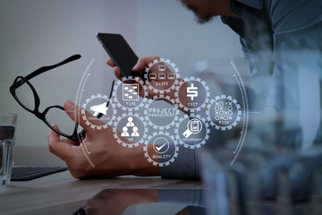 Businessman hand using mobile payments online shopping,pencil,omni channel,laptop computer on wooden desk in modern office,filter effect