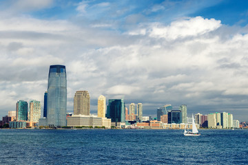 Jersey city skyline and a sailing yacht view from ferry