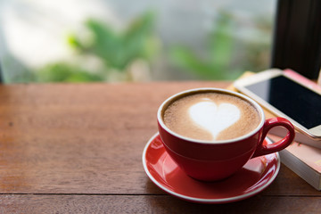 Red cup of coffee with latte art heart shape,soft focus design for valentine background