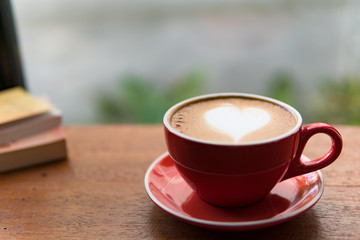 Red cup of coffee with latte art heart shape,soft focus design for valentine background