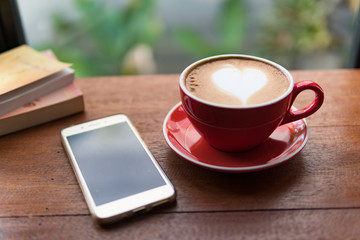 Red cup of coffee with latte art heart shape,soft focus design for valentine background