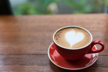 Red cup of coffee with latte art heart shape,soft focus design for valentine background