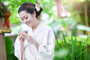 Beautiful girl dress in Bathrobe drinking beverage