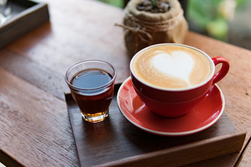 Red cup of coffee with latte art heart shape,soft focus design for valentine background