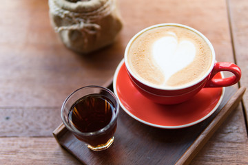 Red cup of coffee with latte art heart shape,soft focus design for valentine background