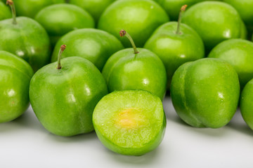 Close Up Of Green Plums Or Greengage showing the flesh and the seed of the fruit Isolated On White Background, Popular Spring Fruits With A Very Sharp Sour Taste Originated In Iran