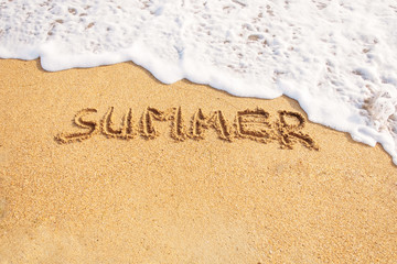 Word summer written on sand.